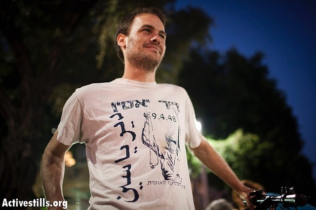 Image of an Israeli activist wearing a shirt reading— in Hebrew and Arabic —"Deir Yassin," during a Tel Aviv event commemorating the Palestinian Nakba.